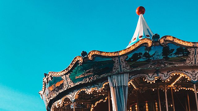 fairground carousel in front of a blue sky