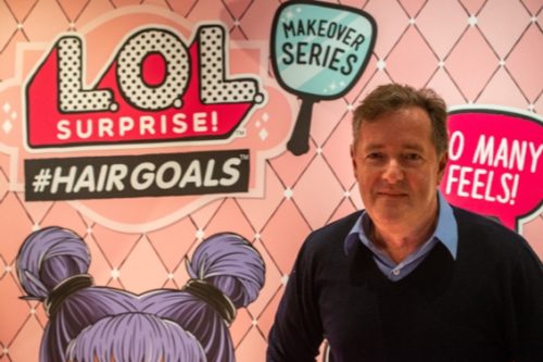 piers morgan in front of a giant pink LOL surprise poster
